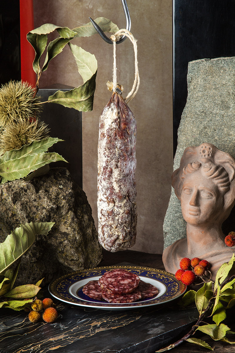 Salame appeso accanto a un busto in terracotta
