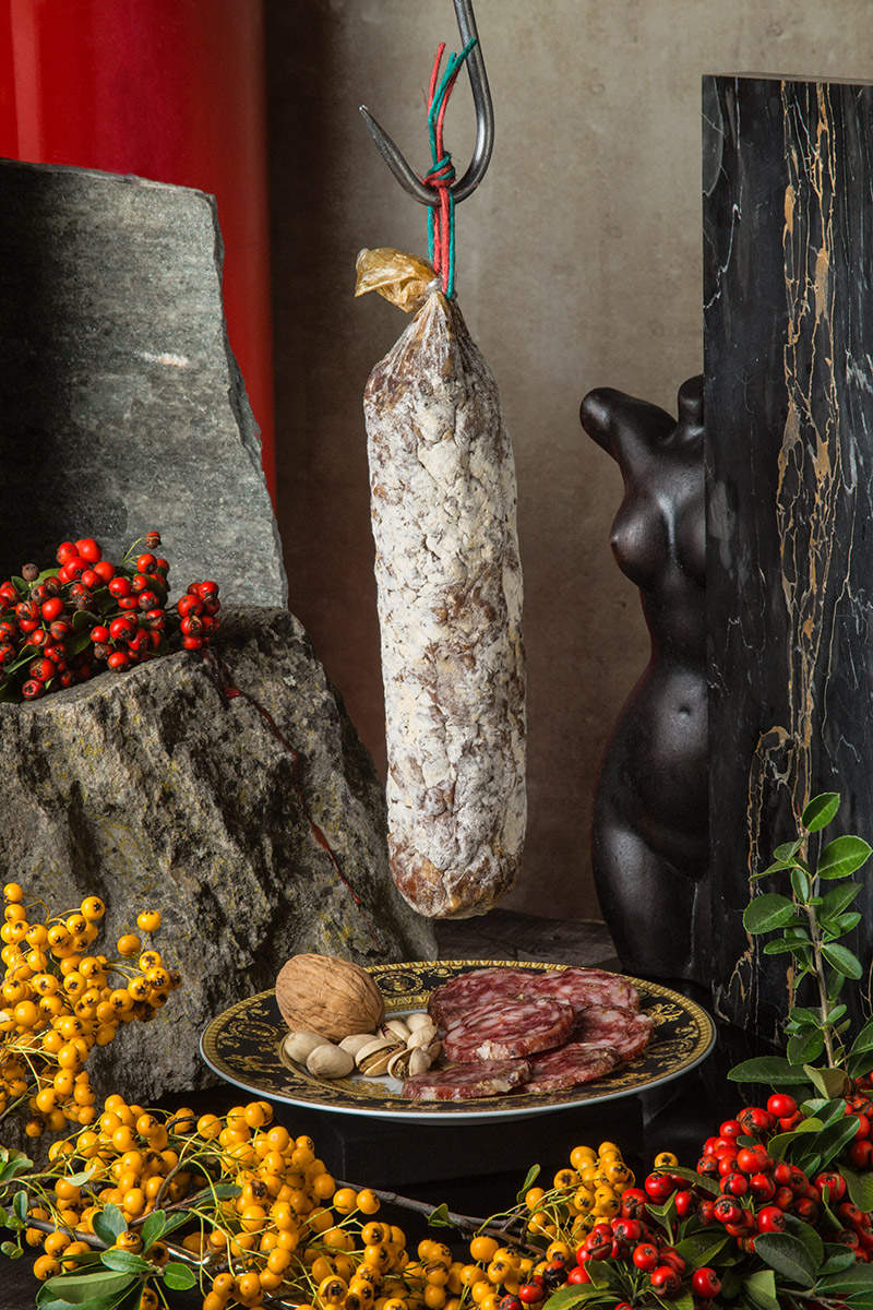 Salame appeso con bacche rosse e gialle e noci
